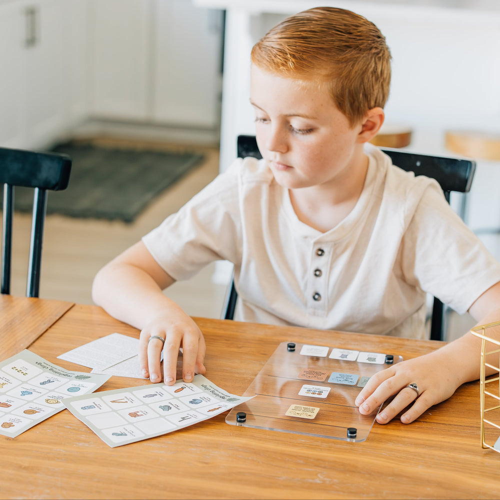 Child sitting at a table with educational materials in a home setting